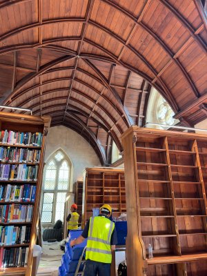 Library shelves with construction workers in foreground